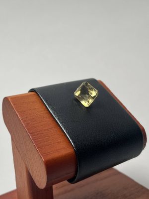 étui à montre avec bracelet en cuir, orné d'une pierre carrée plaquée or, posé sur un socle en bois