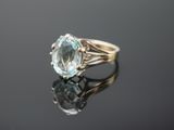 Gros plan sur une bague en or ornée d'une topaze bleue