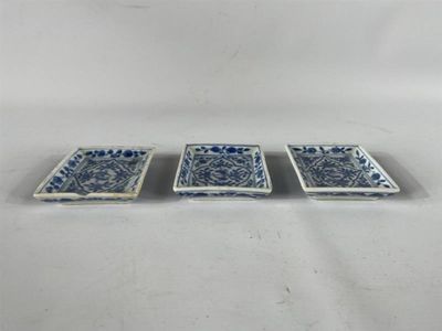 trois petits plats bleus et blancs posés sur une surface blanche
