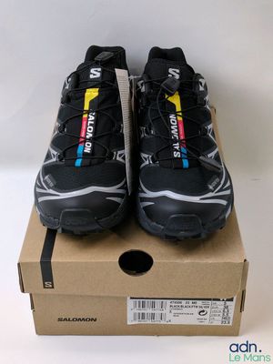 a pair of black running shoes on top of a cardboard box