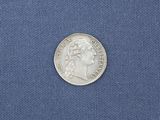 a close up of a silver coin on a blue cloth