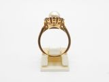 a close up of a gold ring with a pearl on it