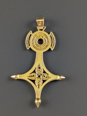 gros plan d'une croix en or sur une surface noire