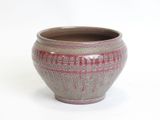 a brown and pink vase sitting on a white surface