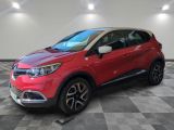 une voiture rouge est garée dans une pièce au sol en damier