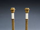 a pair of antique brass candles with white candlesticks