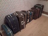 several pieces of luggage are lined up against a wall in a room