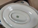 a white plate with a green flower on it in a box