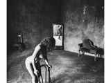 photographie en noir et blanc d'une femme nue assise sur une chaise