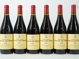 six bouteilles de vin sont alignées sur une table