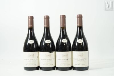 quatre bouteilles de vin sont alignées sur une surface blanche