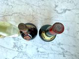 two bottles of wine sitting next to each other on a marble table