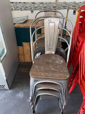 many red chairs and a metal chair in a room