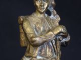 bronze statue of a woman holding a bird on a black background