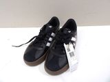 adidas superstar black and white sneakers with gum soles on a white surface