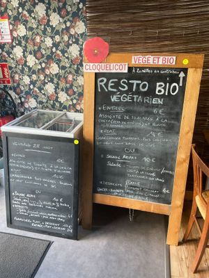 des tables et des chaises dans un restaurant où le menu est inscrit sur un tableau noir