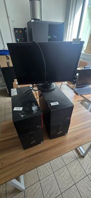 three computer monitors sitting on a desk with a laptop