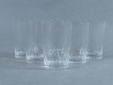 quatre verres transparents posés les uns à côté des autres sur une table