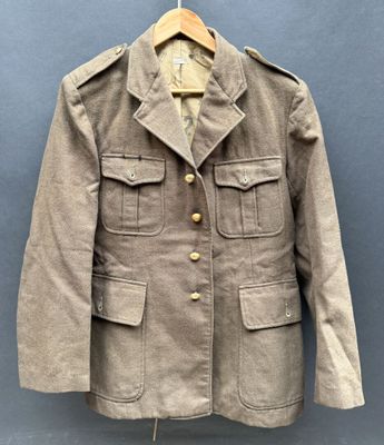 une vieille veste militaire suspendue à un cintre accroché au mur