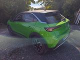 a green car that is parked on the side of the road