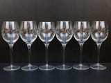 six verres à vin vides alignés sur une table