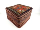 a small ottoman with a colorful design on it
