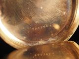 a close up of a gold pocket watch on a black surface