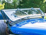 a close up of a blue car parked in the grass