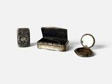 une petite boîte en argent sur laquelle sont fixés un miroir et une bague
