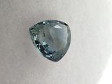 a close up of a blue diamond on a white surface