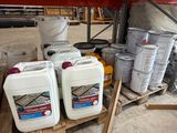 plusieurs conteneurs remplis de liquide posés sur une palette dans un entrepôt