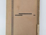 an old book with a brown cover sitting on top of a white table