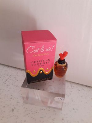 une photo montrant un flacon de parfum posé à côté d'une boîte sur un comptoir
