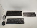 two keyboards and a mouse sitting on a desk