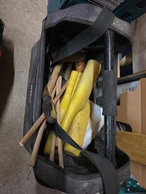 un sac rempli d'outils posé par terre