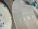 a white plate with blue flowers on it next to a white plate with blue flowers on it