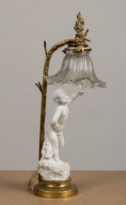 a lamp that has a statue on it on a table