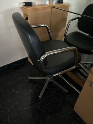 une chaise noire posée à côté d'un bureau dans une pièce