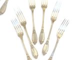 a lot of forks and spoons on a white surface
