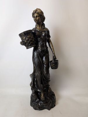 bronze statue of a woman holding a basket of flowers