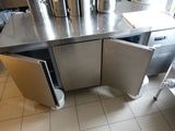 un plan de travail en acier inoxydable avec une porte ouverte dans une cuisine