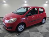 the small red car is parked on a checkered tile floor