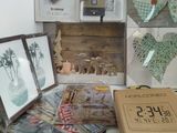a table with a box, picture frames, pictures, and other items on it