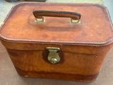 a brown suitcase sitting on the floor with a handle