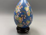a close up of a blue egg with flowers painted on it
