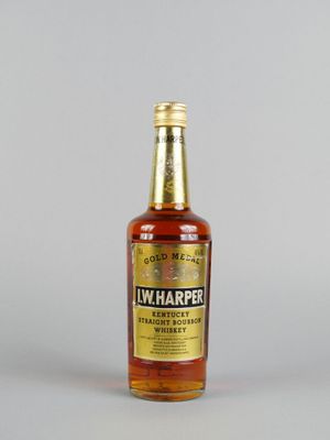 un gros plan d'une bouteille de whisky posée sur une surface blanche