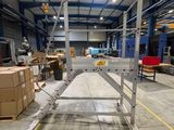 une grande table en métal au milieu d'un entrepôt