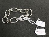 a silver chain bracelet with tags attached to it