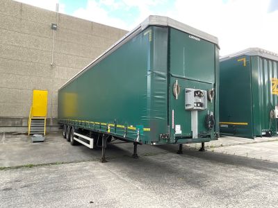 two green semi trailers parked in a parking lot