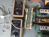 a lot of toy trains on a table with wires